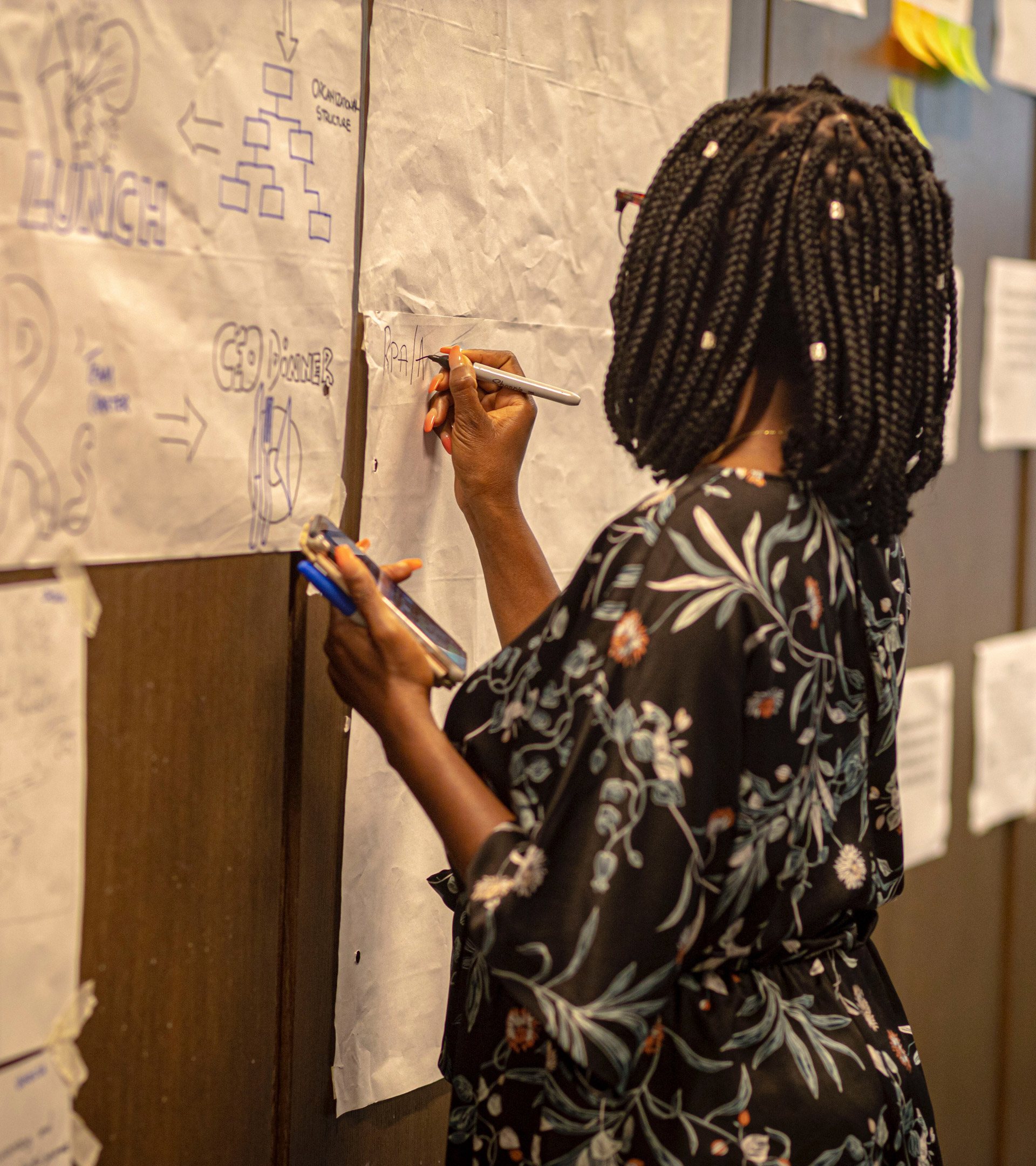 GRID-Impact-31 A woman writing something with a sharpie on a big paper hanging on the wall