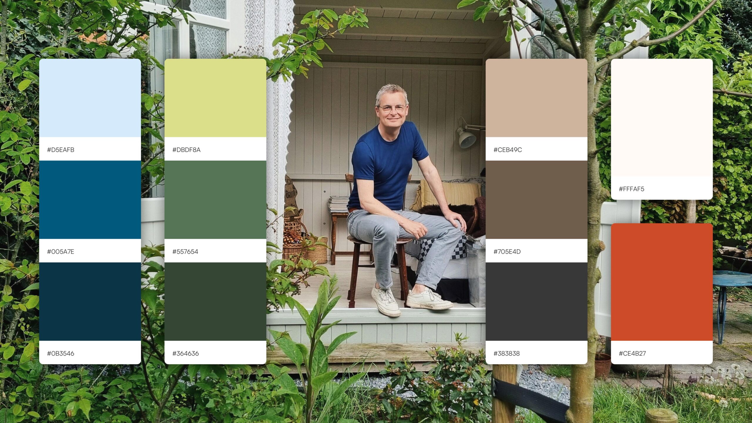 Philippe-Metz-Website-05 A photo of Philippe Metz sitting in a shed in a garden. On the photo there are color swatches in a range of blues, green and browns.