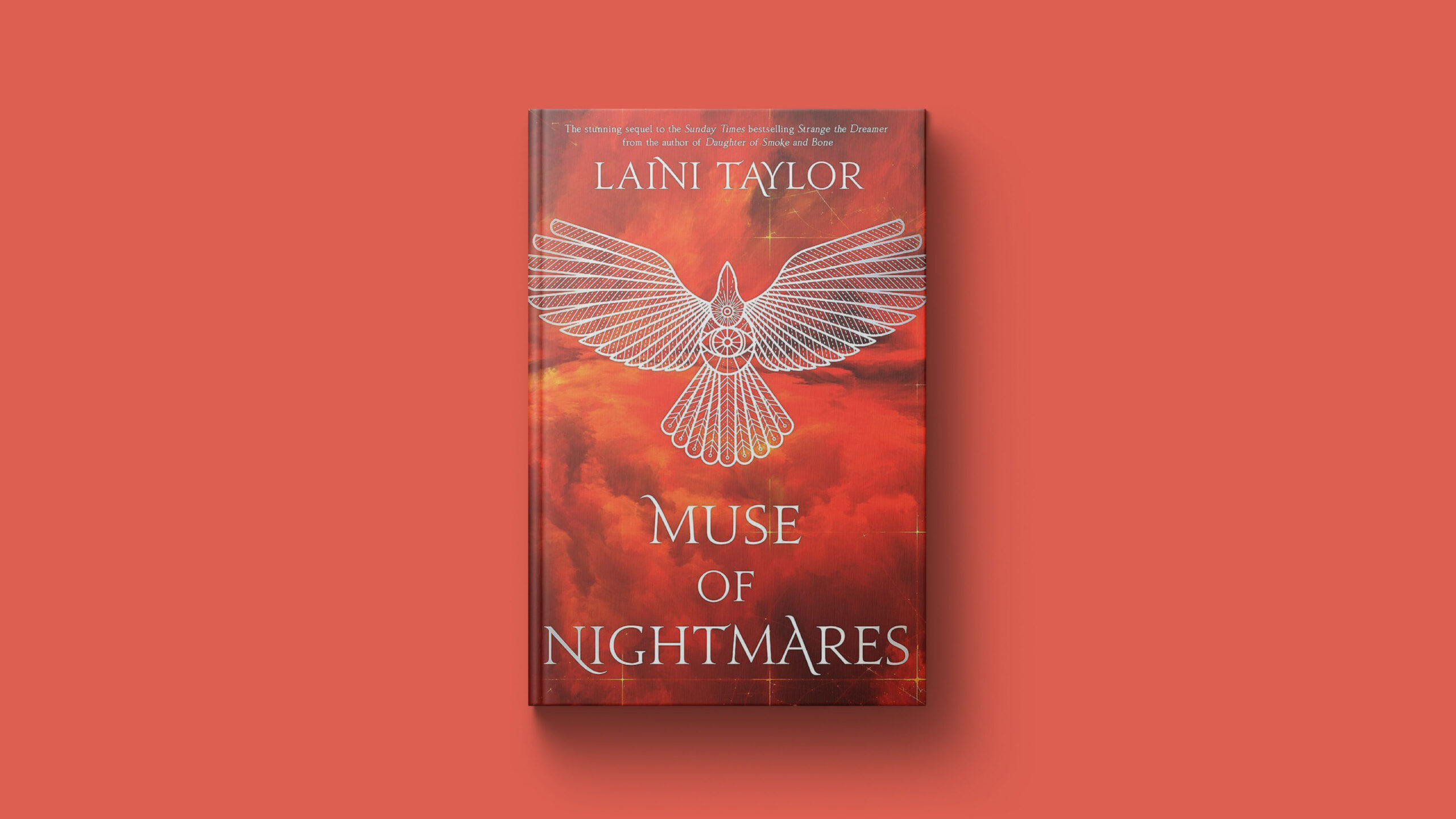 An orange/red background with the book 'Muse of Nightmares' by Laini Taylor laying on it. The book is red with silver lettering, and has a graphic illustration of an eagle in the center.
